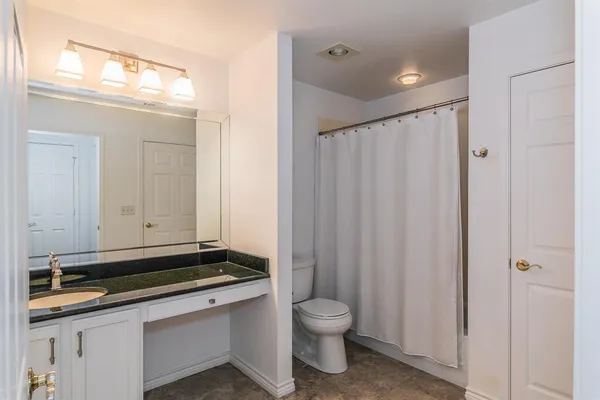 a bathroom with a sink a toilet and a mirror