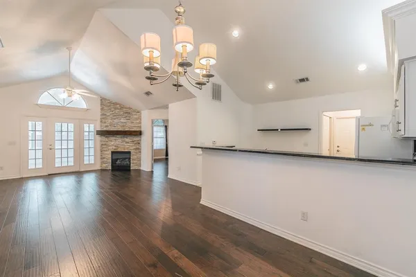 a view of a room with wooden floor and chandelier