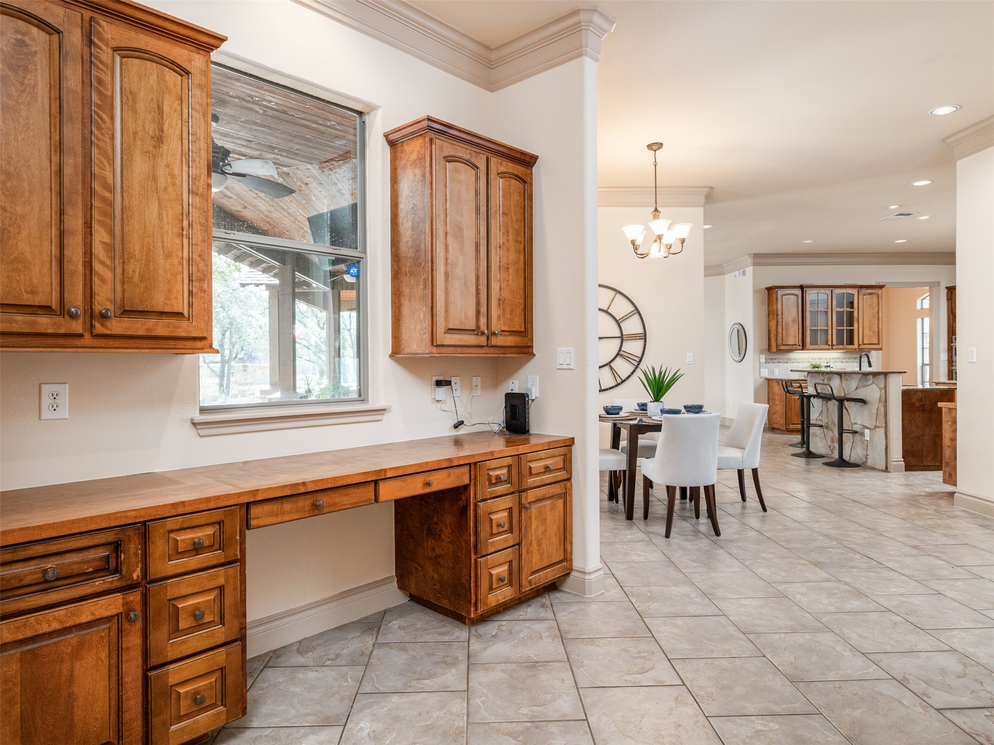 139 Ware Drive Buda, TX 78610 - Photo 12 of 39 Kitchen with wood finish cabinets, crown molding, built in desk, wood counters, and light tile patterned floors
