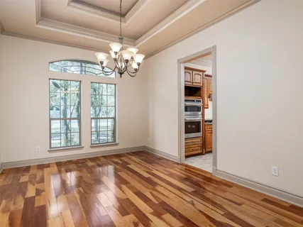 a view of an empty room with a window and chandelier