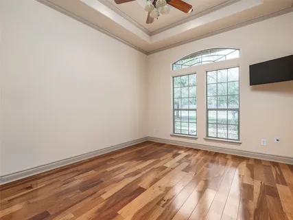 a view of an empty room with a window and wooden floor