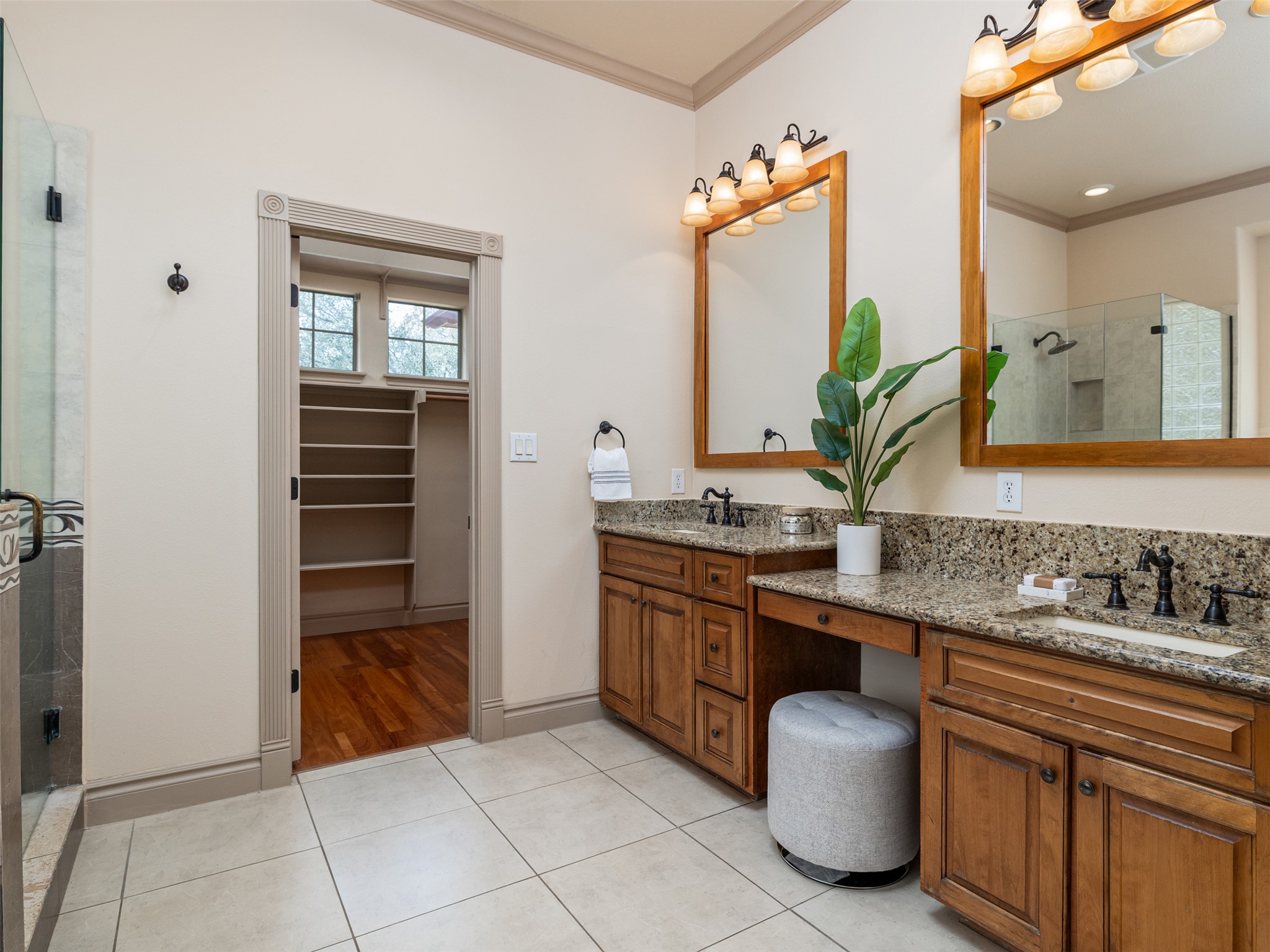 139 Ware Drive Buda, TX 78610 - Photo 17 of 39 Bathroom with a shower stall, crown molding, double vanity, a walk in closet, and light tile patterned floors