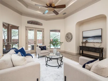 a living room with furniture a clock potted plant and a large window