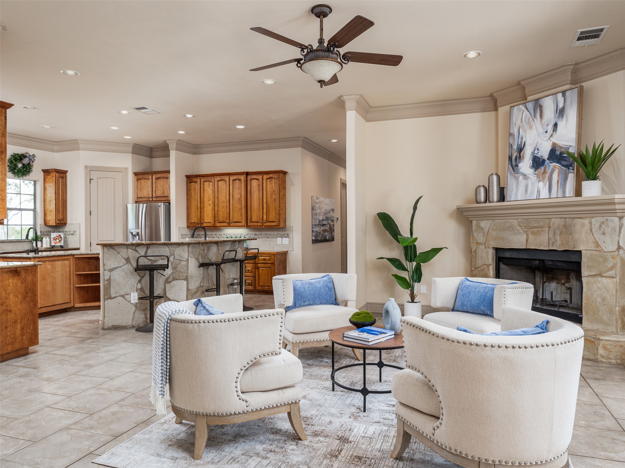 139 Ware Drive Buda, TX 78610 - Photo 5 of 39 Living area featuring a ceiling fan, crown molding, a stone fireplace, and recessed lighting