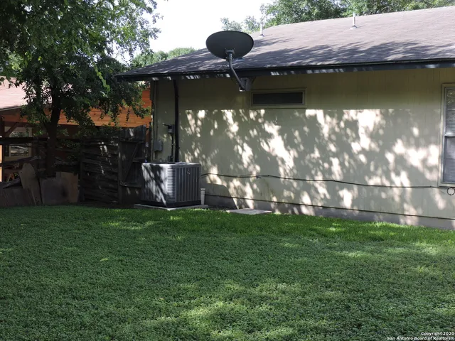 a backyard of a house with a yard and outdoor seating