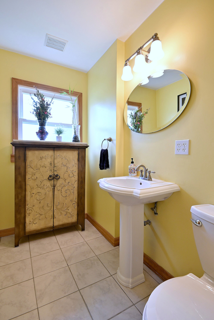 1495 East Algonquin Road Des Plaines, IL 60016 - Photo 13 of 41 a bathroom with a sink a mirror and a toilet