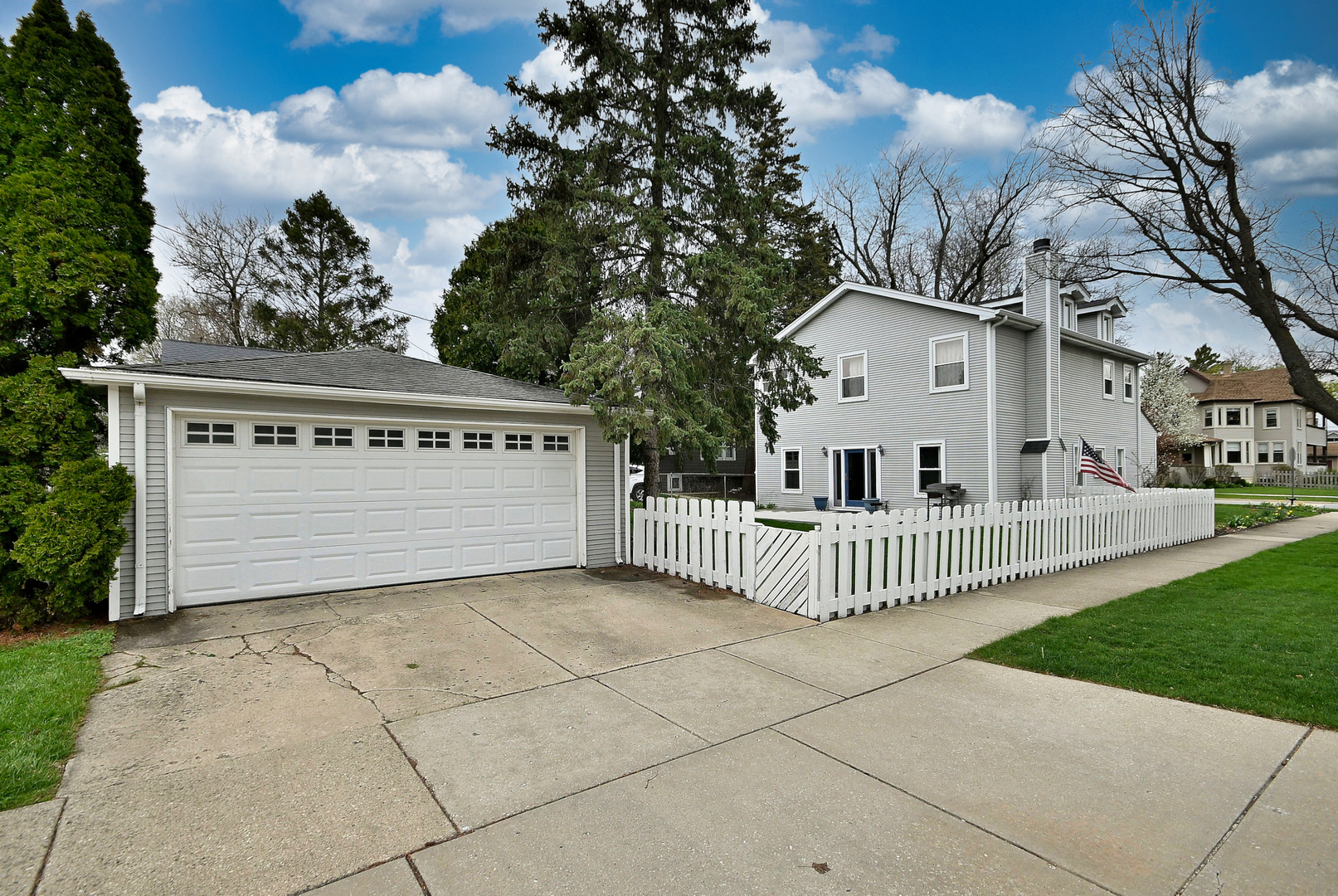 1495 East Algonquin Road Des Plaines, IL 60016 - Photo 5 of 41 a view of a white house with a small yard and large tree