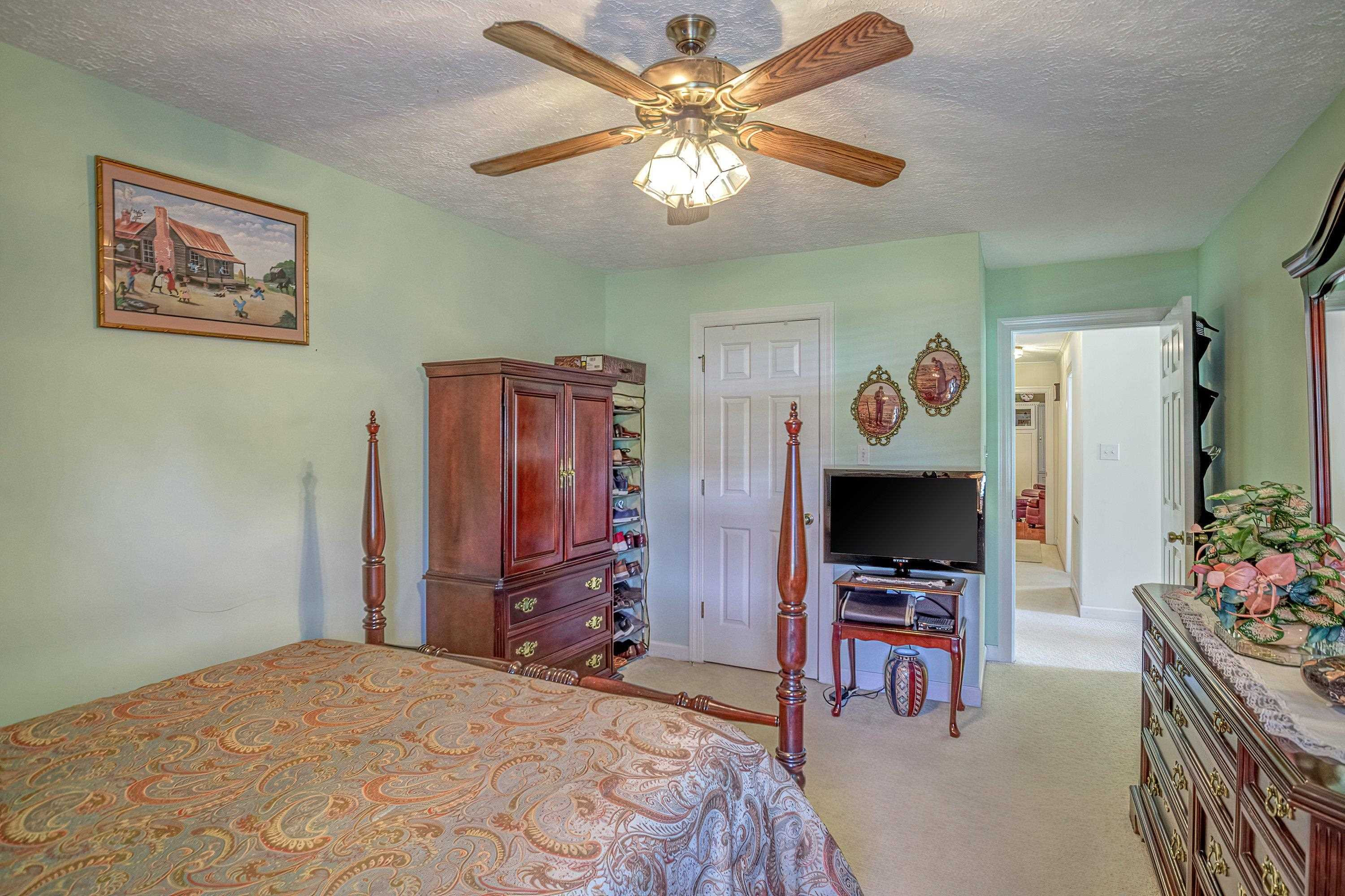 7191 Suttontown Road Faison, NC 28341 - Photo 15 of 40 a bedroom with a bed and a flat screen tv