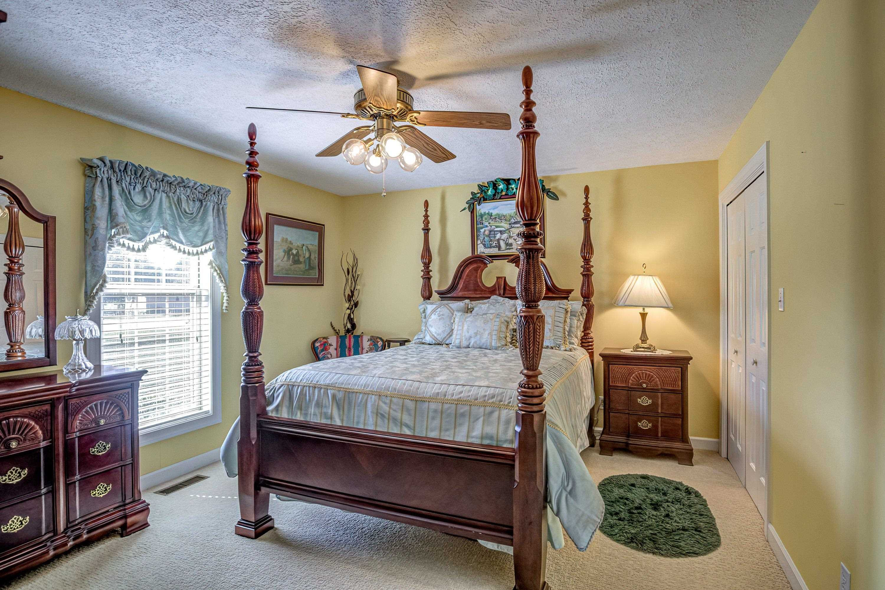 7191 Suttontown Road Faison, NC 28341 - Photo 16 of 40 a bedroom with a bed and a chandelier
