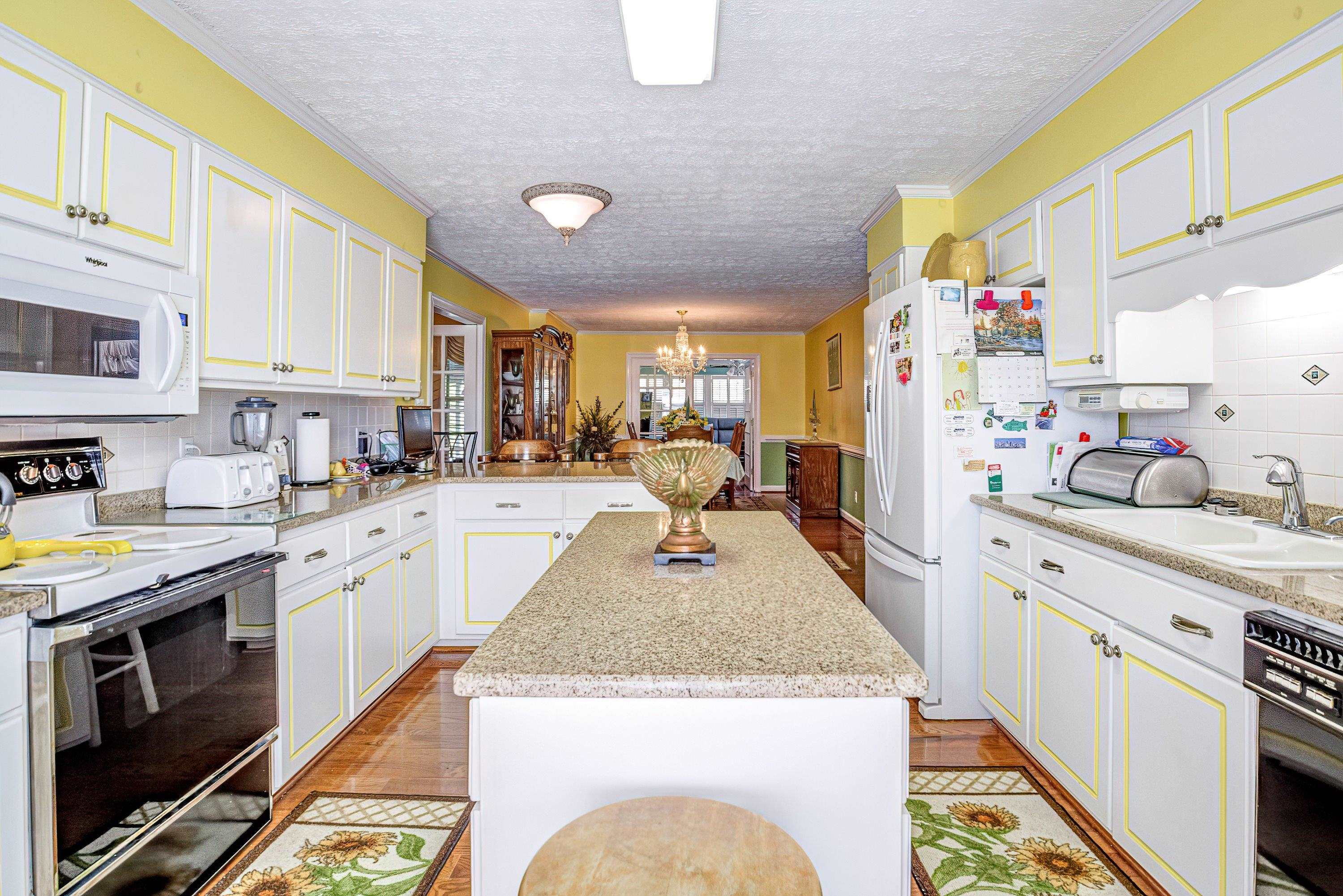 7191 Suttontown Road Faison, NC 28341 - Photo 33 of 40 a large white kitchen with stainless steel appliances granite countertop a stove and a sink