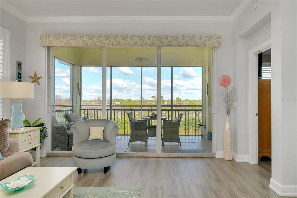 10501 Amberjack Way, Unit 301 Englewood, FL 34224 - Photo 17 of 76 a living room with furniture and a floor to ceiling window