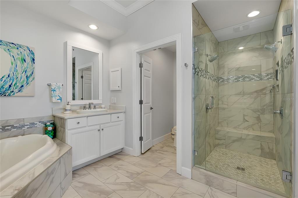 10501 Amberjack Way, Unit 301 Englewood, FL 34224 - Photo 25 of 76 a bathroom with a granite countertop sink a mirror a bathtub and a shower