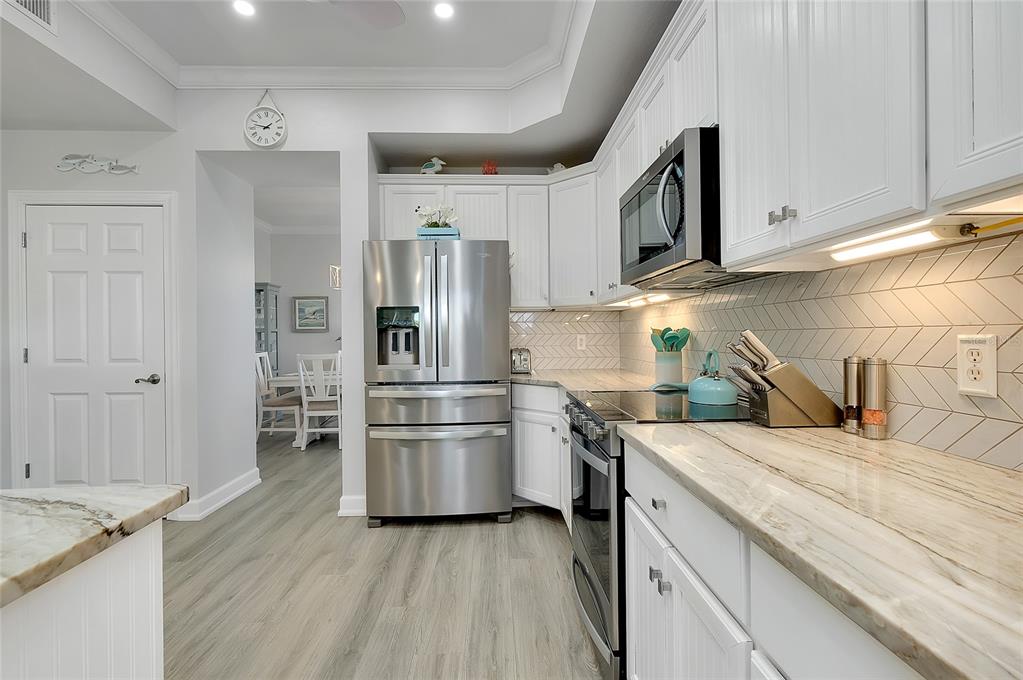 10501 Amberjack Way, Unit 301 Englewood, FL 34224 - Photo 9 of 76 a kitchen with stainless steel appliances and wooden cabinets