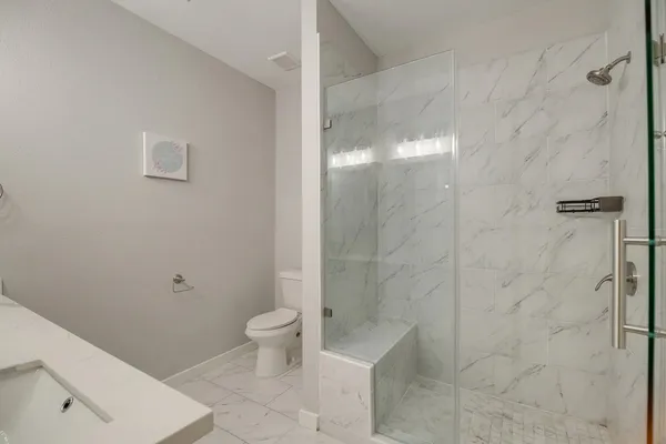 a bathroom with a toilet and a shower