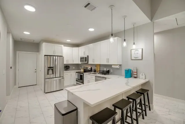 a kitchen with refrigerator and chairs
