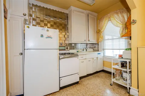 a kitchen with appliances a sink and a refrigerator
