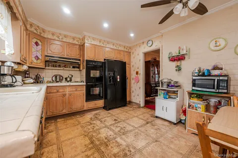 a kitchen with stainless steel appliances kitchen island granite countertop a refrigerator and a stove top oven