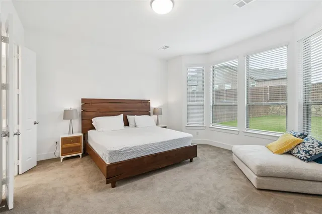 a spacious bedroom with a bed and glass window