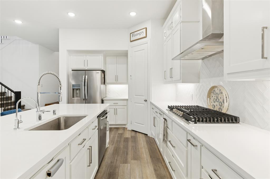 4313 Expedition Drive Oak Point, TX 75068 - Photo 10 of 40 a kitchen with stainless steel appliances kitchen island a sink stove and cabinets
