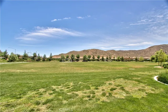 a kitchen with stainless steel appliances granite countertop a sink dishwasher a refrigerator and white cabinets with wooden floor