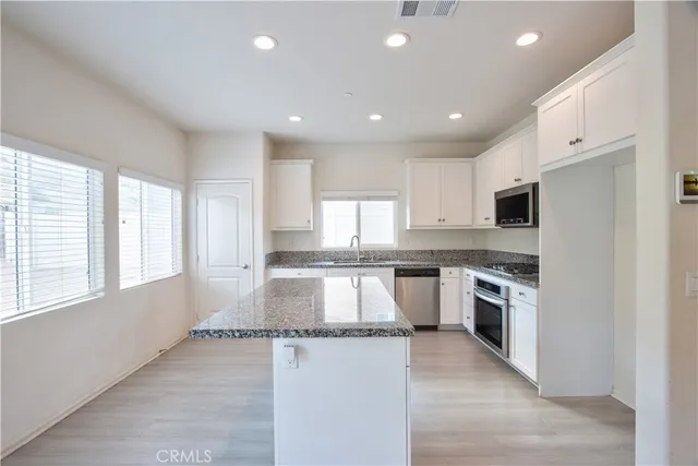 a kitchen with granite countertop a sink a stove and microwave