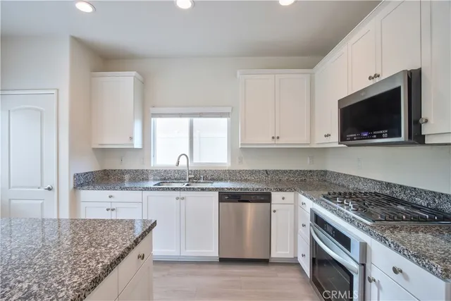 a view of a kitchen with wooden floor electronic appliances and window