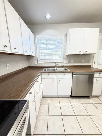 a kitchen with a sink a stove cabinets and white appliances