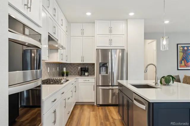 a kitchen with a sink stainless steel appliances and white cabinets