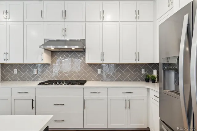 a kitchen with white cabinets and white appliances