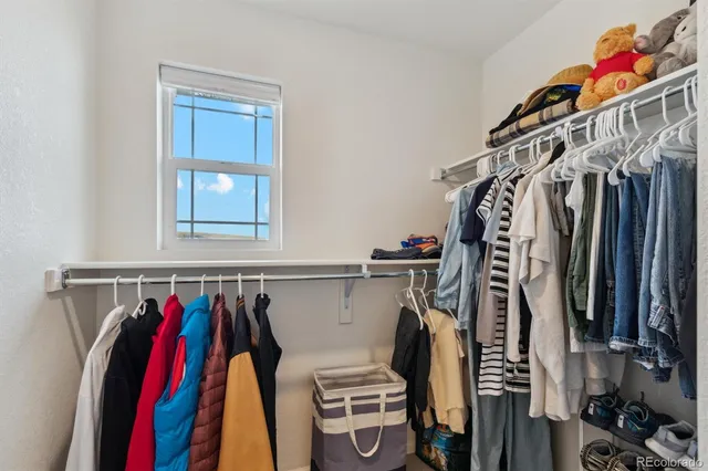 a view of walk in closet with clothes and shoes