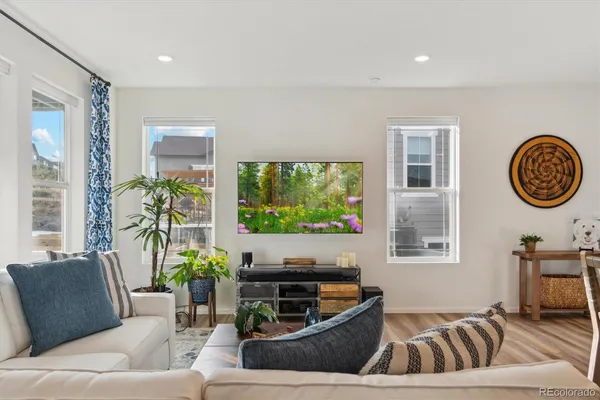 a living room with furniture a large window and a flat screen tv