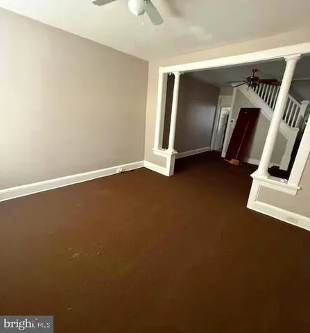 an empty room with staircase and wooden floor