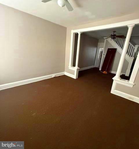 407 Cambria Street Baltimore, MD 21225 - Photo 4 of 13 an empty room with staircase and wooden floor