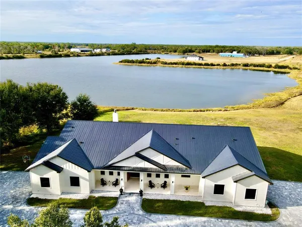 an aerial view of house with yard and swimming pool