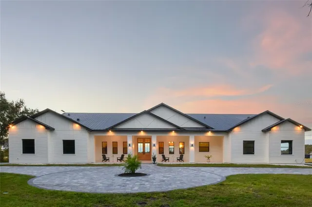 a view of a house with backyard and tree s