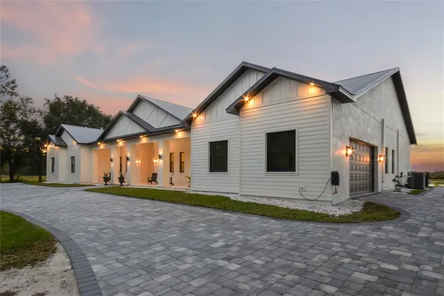 a living room with stainless steel appliances kitchen island granite countertop a sink a stove and a flat screen tv