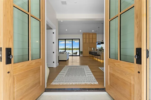 a kitchen with stainless steel appliances granite countertop a stove a sink a oven a dining table and chairs with wooden floor