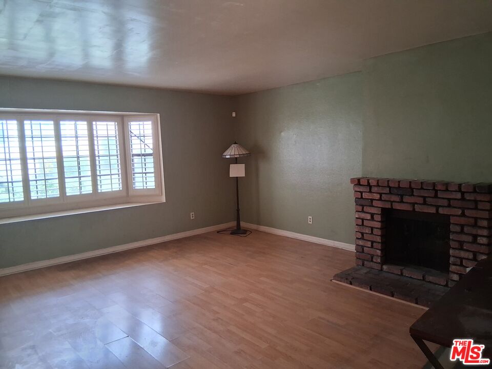 4195 Kingsley Street, Unit 43 Montclair, CA 91763 - Photo 11 of 13 an empty room with a fireplace and windows