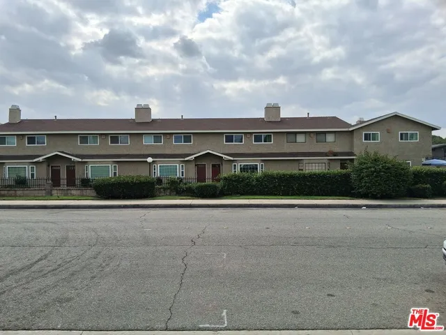 a view of a white house with a big yard and large trees