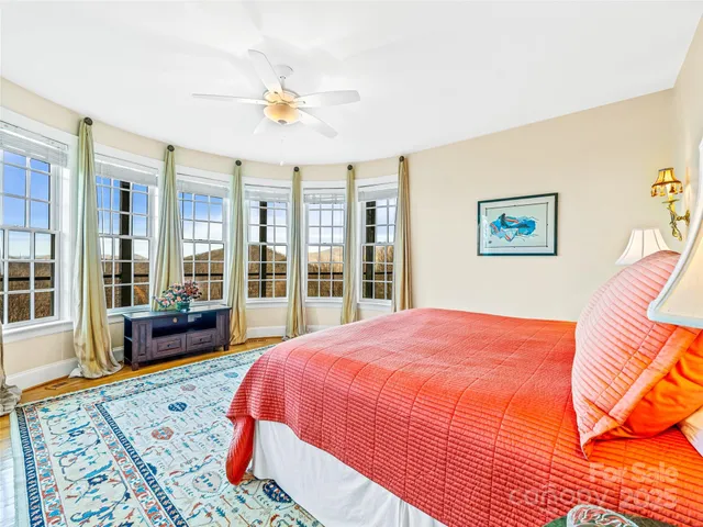 a bedroom with a large bed and a chandelier