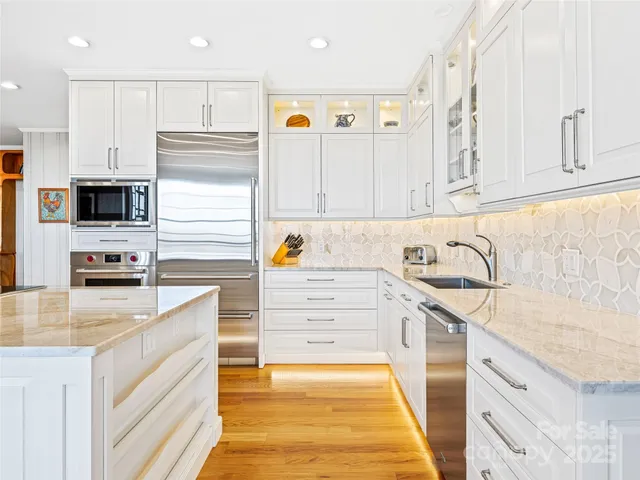 a kitchen with stainless steel appliances granite countertop a sink and a stove