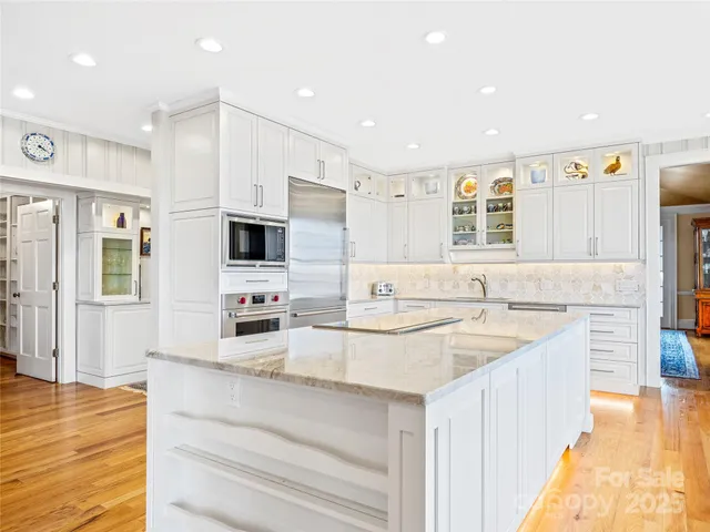 a kitchen with stainless steel appliances kitchen island granite countertop a sink and cabinets