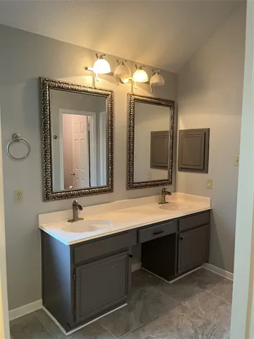 a bathroom with a double vanity sink and a mirror