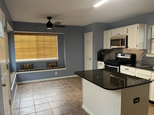 a kitchen with a sink a counter top space cabinets and stainless steel appliances