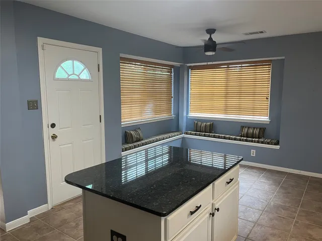 a kitchen with granite countertop a sink a counter top space and cabinets