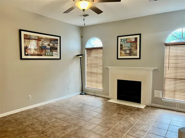 a view of an empty room with a fireplace and a window