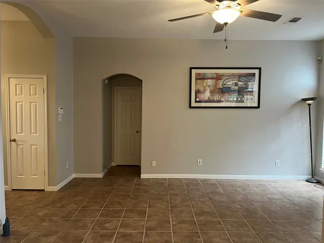 a view of an empty room with a chandelier fan