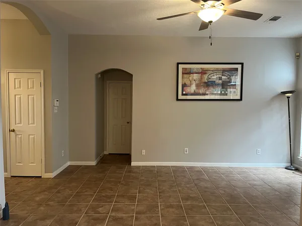 a view of an empty room with a chandelier fan