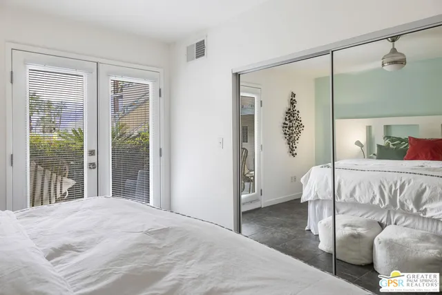 a bedroom with a bed and a large window