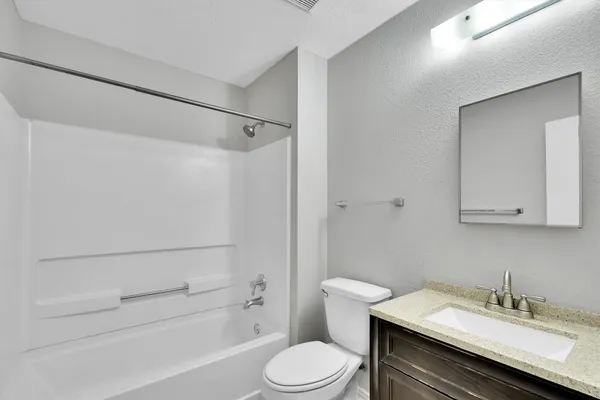 a bathroom with a sink toilet vanity and shower